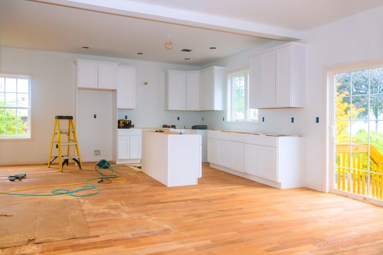 Bright airy renovated kitchen with new white cabinets and hardwood flooring