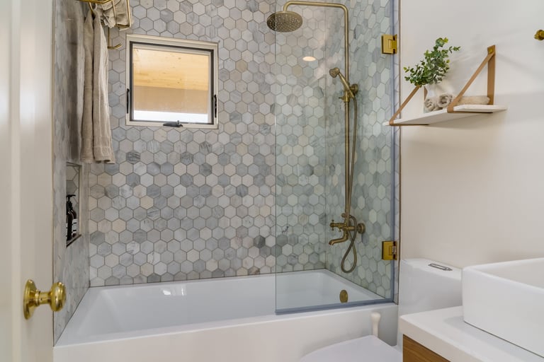 Modern bathroom with hexagonal tile shower tub and gold brass fixtures